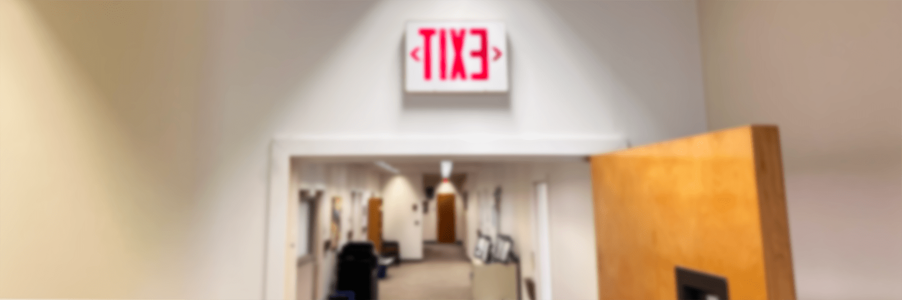 Blurred image of exit sign in hallway