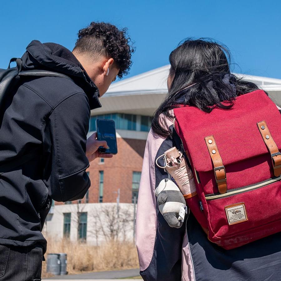 IT Students check cellphones outside Uhall photo by student Santiago Chaparro